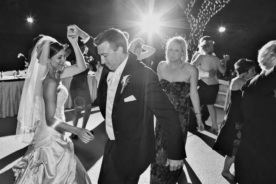 Couple dancing among guests at the reception
